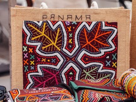 Vibrant handcrafted textiles with intricate patterns displayed at a Panama market stall.