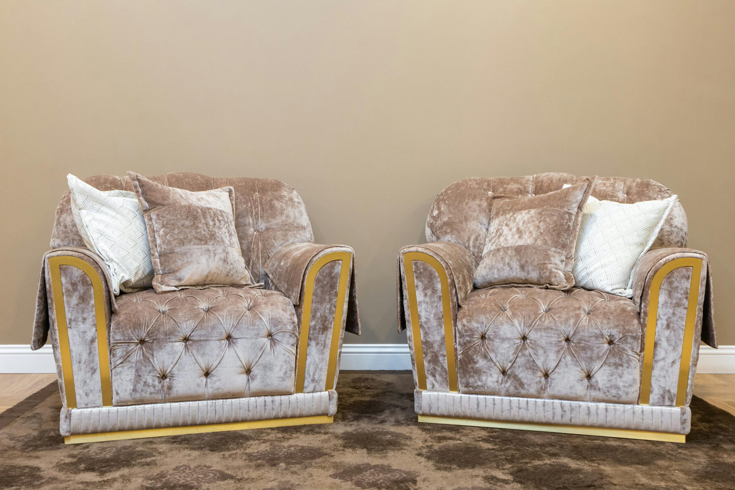 Two plush velvet armchairs in a cozy modern living room setting.